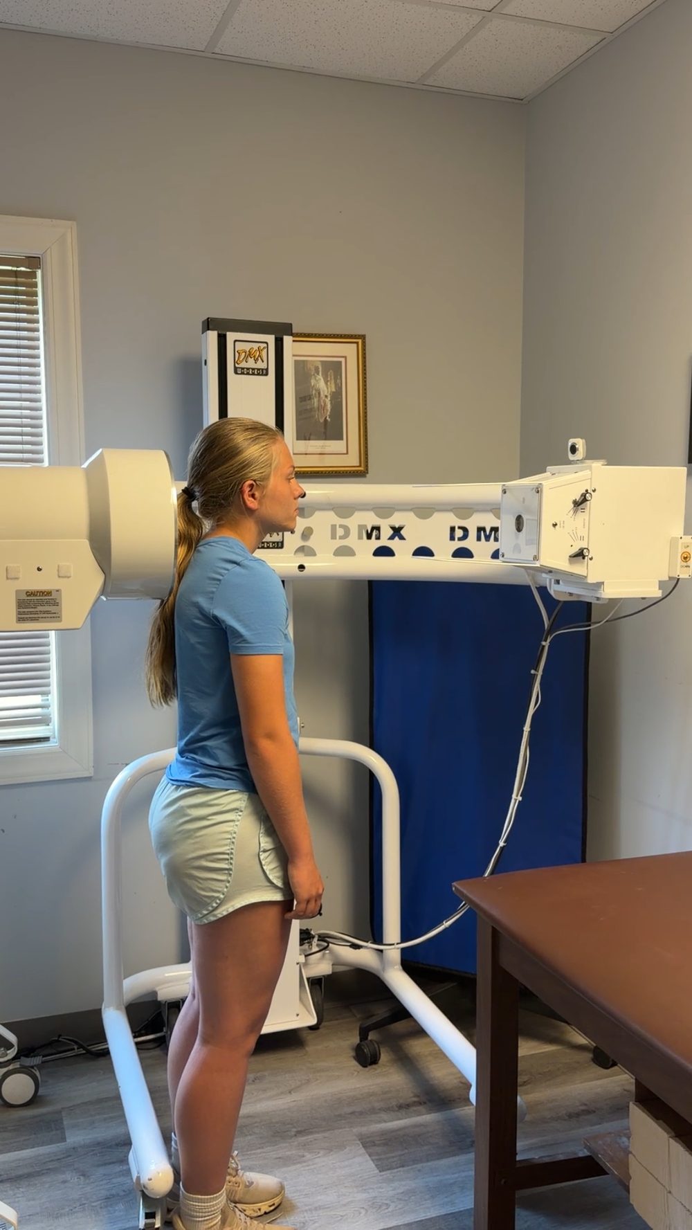 A patient standing in the digital motion X-ray (DMX) machine